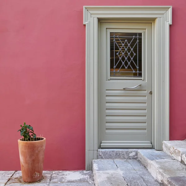 Grécia, porta cinza na parede da casa fúcsia colorido — Fotografia de Stock