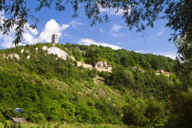 Lyadova, Ukraine - 09.06.2019: panorama of Beheading of John the Baptist Rock Friary with ancient monk caves cut in coquina cliff and modern monastery building, bell tower at Dniester river bank, Christian orthodox believers cult pilgrimage