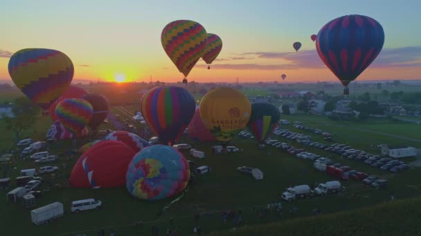 無人機に見られる晴れた夏の日の日の出に熱気球フェスティバルで熱気球の朝の打ち上げの空中ビュー — ストック動画