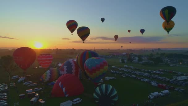 無人機に見られる晴れた夏の日の日の出に熱気球フェスティバルで熱気球の朝の打ち上げの空中ビュー — ストック動画