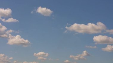 Beyaz kabarık bulutlu mavi gökyüzü yavaşça soldan sağa hareket ediyor