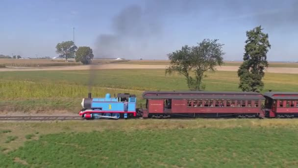 ペンシルベニア州ストラスバーグ 2019年9月 無人偵察機によって見られる晴れた日に幸せな子供たちでいっぱいの黒い煙と乗客の車を引く列車トーマスの空中ビュー — ストック動画