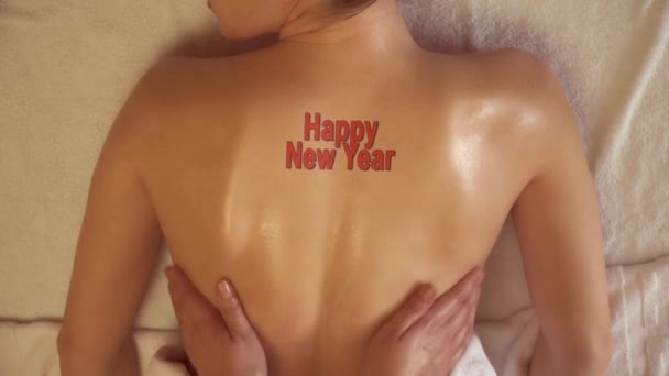 Uma Mulher Recebendo Massagem Com Tatuagem Feliz Ano Novo — Vídeo de Stock