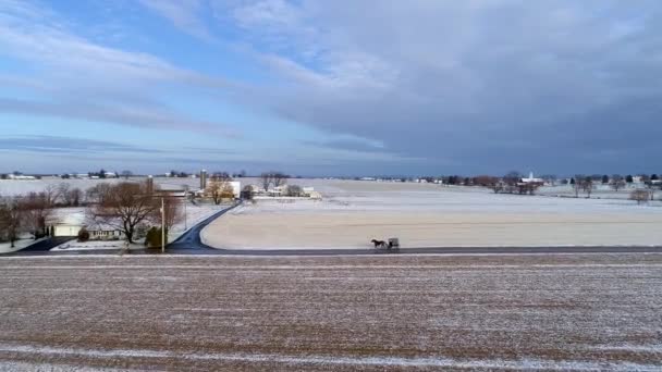 アミッシュ地方の空の景色と馬とバギー光の雪の秋の後の早朝に道路に沿って旅行 — ストック動画