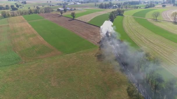 Vue aérienne d'une ancienne machine à vapeur restaurée voyageant à travers les terres agricoles soufflant de la fumée et de la vapeur dans mon chemin de drones 