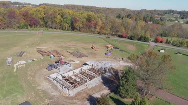 Vue aérienne d'une ancienne grange à ossature de bois en cours de reconstruction et de restauration d'un drone entourant un chantier de construction 