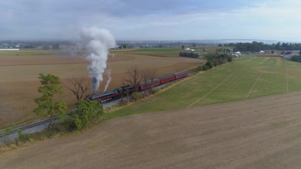 2019年10月ペンシルベニア州ストラスバーグ 晴れた日に農地を眺めながら乗用車を引きながら蒸気と煙を吹くN W蒸気機関の空中角度ビュー — ストック動画
