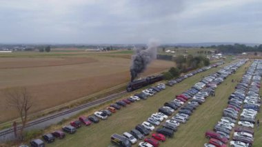 Strasburg, Pennsylvania, Ekim 2019 - Güneşli bir günde park halindeki arabaları gören yolcu arabalarını çekerken N & W buhar makinesinin hava açısı