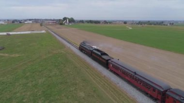 Strasburg, Pennsylvania, Ekim 2019 - Yenilenmiş bir N & W buhar makinesinin havadan görünüşü ve arkası ve manzarası, çiftlikte seyahat ederken antika yolcu arabalarını çekerken duman ve buhar üflüyor