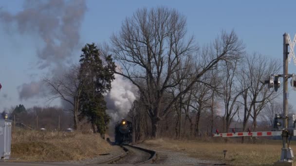 晴れた冬の日に煙と蒸気で近づいてアンティーク復元された蒸気機関車と乗用車 — ストック動画