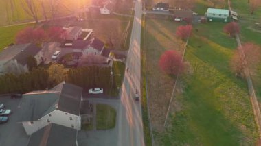 Güneşli bir bahar gününde öğleden sonra bir at arabasını takip etmenin havadan görüntüsü.