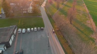 Güneşli bir bahar gününde öğleden sonra bir at arabasını takip etmenin havadan görüntüsü.