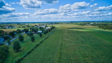 Güneşli bir yaz gününde ahır ve silolarla Amish kırsalının havadan görünüşü