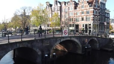 Amsterdam, Hollanda - 21 Ekim 2019: Amsterdam kanalında tarihi binalar ve Hollanda 'da sonbahar ağaçları olan tekneler 21 Ekim 2019