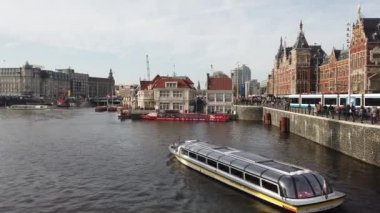 Amsterdam, Hollanda - 21 Ekim 2019: Amsterdam Kanalı 'nda turistlerle dolu bir tur teknesi Amsterdam, Hollanda' da tarihi binalar ve sonbahar ağaçları ile 21 Ekim 2019 'da denize açıldı.