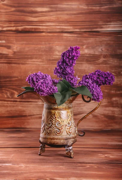 lilac in vintage vase on old wooden background