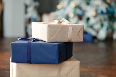 Noel hediyesi süslemeleri. Bir Noel ağacının arka planında çok renkli hediye kutuları ve çok renkli bokeh. Yeni yıl arifesi.