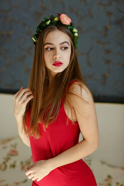 Primer plano vertical retrato de hermosa joven en un vestido rojo con corona de flores en la cabeza — Foto de Stock