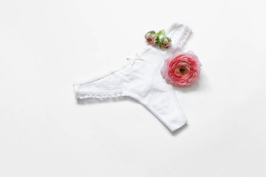 Düz yatıyordu seksi kadın iç çamaşırları ve beyaz arka planda çiçekleri, üst manzara. İzole edilmiş. Temizlik ve Kadın Sağlığı kavramı
