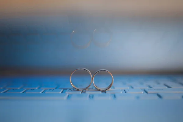 Wedding rings on the keyboard of notebook computer. Love concept. Text space. — Stock Photo, Image