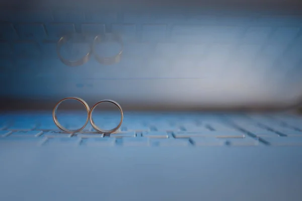 Wedding rings on the keyboard of notebook computer. Love concept. Text space. — Stock Photo, Image