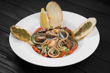 Deniz ürünleri salatası. Midye ve karides beyaz bir plaka üzerinde.