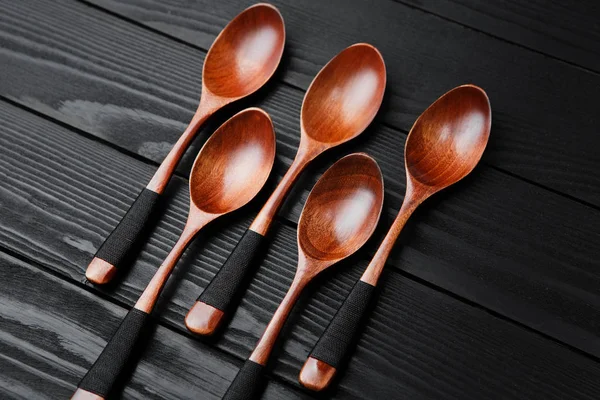 Wooden vintage spoons on the black wood background. — Stock Photo, Image