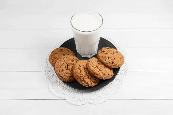 Tasty cookies and glass of milk on rustic white wooden background. — Stock Photo, Image