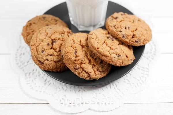 Tasty cookies and glass of milk on rustic white wooden background. — Stock Photo, Image
