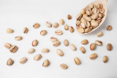 Antep fıstığı tahta kaşık beyaz tahta arka plan üzerinde üzerinde. Yakın çekim