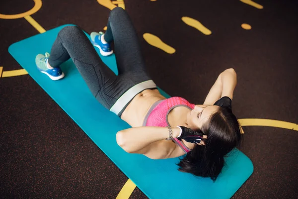 Atletische jonge vrouw oefeningen abs op de fitness mat. — Stockfoto