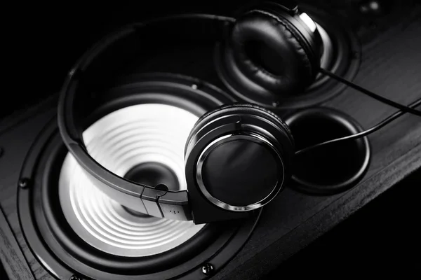 Фотографія чорних навушників на музичному аудіо динаміку. Крупним планом . — стокове фото
