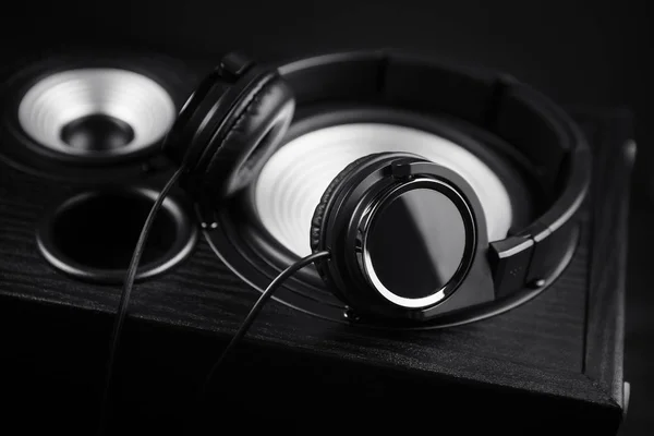Фотографія чорних навушників на музичному аудіо динаміку. Крупним планом . — стокове фото