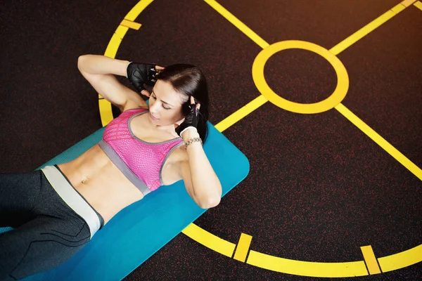 Atletische jonge vrouw oefeningen abs op de fitness mat. — Stockfoto