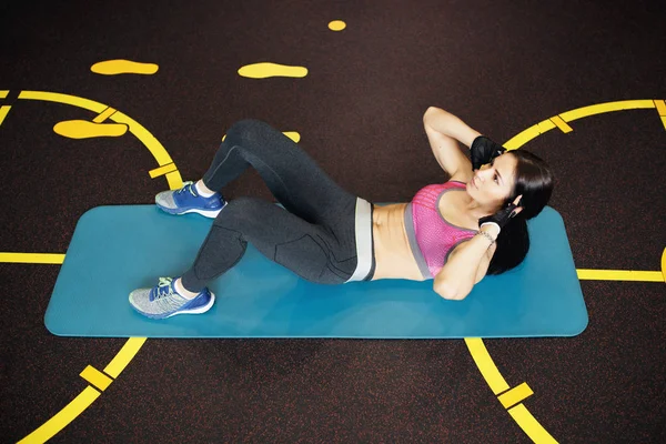 Atletische jonge vrouw oefeningen abs op de fitness mat. — Stockfoto