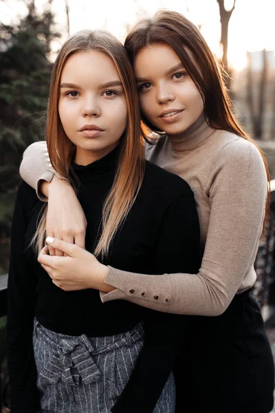 Belles deux jeunes sœurs jumelles avec sérieux en tenue décontractée au parc d'automne. Caméra de regard . — Photo