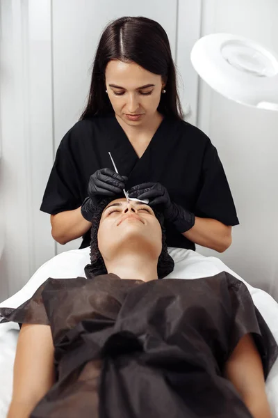 Cosmetoloog maken procedure voor het reinigen van de huid met stalen gereedschap van mee-eters en acne in cosmetologie centrum. — Stockfoto