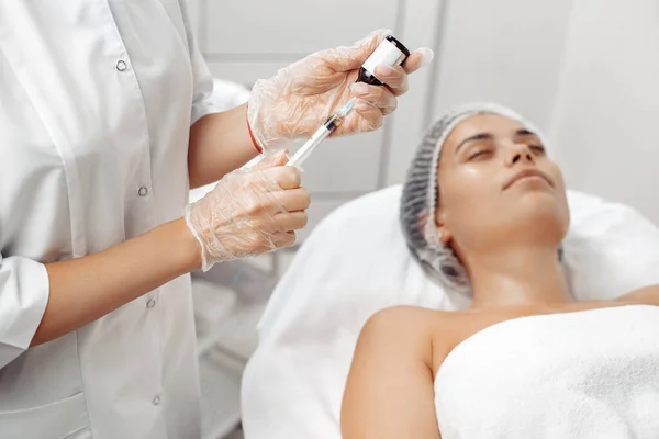 Cosmetoloog handen houden spuit en geneesmiddel voor schoonheid gezicht injecties in salon. — Stockfoto