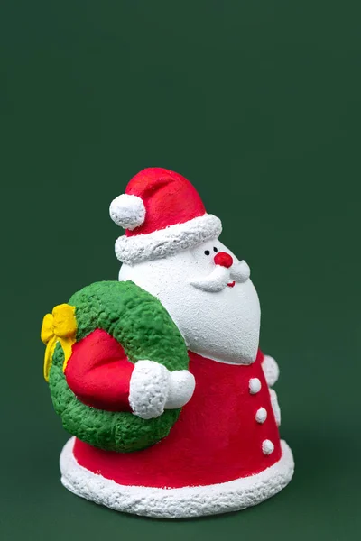 Lustige Gips bunte Weihnachtsmann isoliert über grünem Hintergrund. Neujahrs- und Weihnachtskonzept. — Stockfoto
