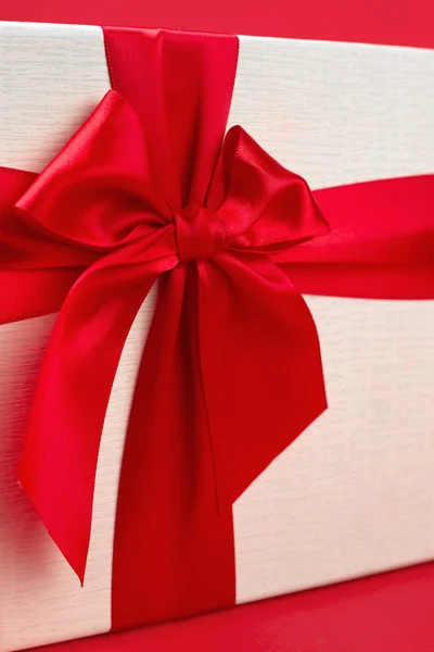 Довольно минималистский рождественский подарочный коробок с лентой на красном фоне . — стоковое фото