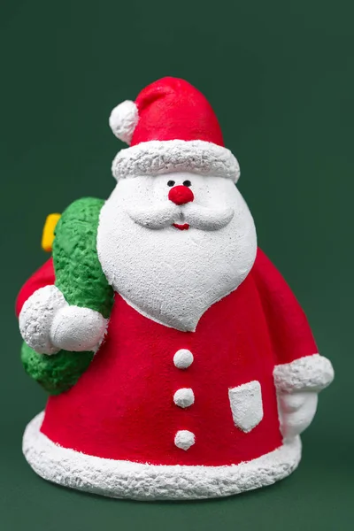 Volle Länge bunte Gips Weihnachtsmann isoliert über grünem Hintergrund. Neujahrs- und Weihnachtskonzept. — Stockfoto
