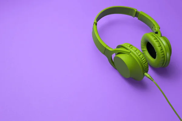 Elegantes auriculares modernos de color verde cian aislados sobre fondo púrpura . —  Fotos de Stock