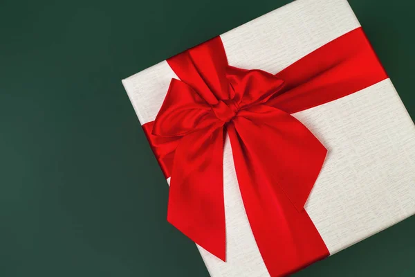 Carino minimalista scatola regalo di Natale con nastro isolato su sfondo verde . — Foto Stock