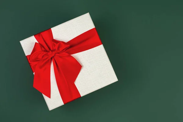 Carino minimalista scatola regalo di Natale con nastro isolato su sfondo verde . — Foto Stock