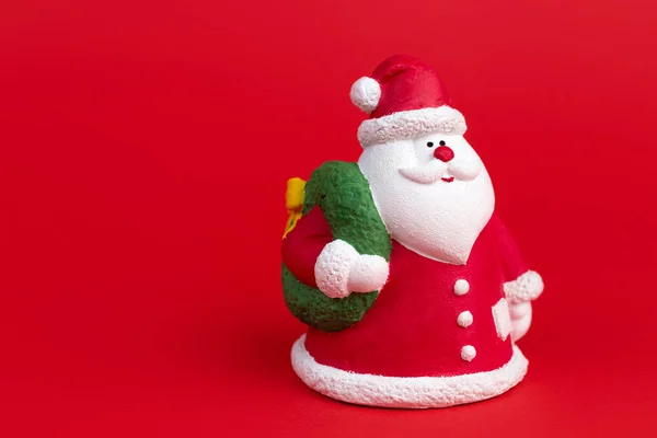 Niedlichen Gips bunten Weihnachtsmann isoliert über rotem Hintergrund. Neujahrs- und Weihnachtskonzept. — Stockfoto