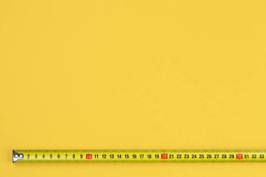 Makro ölçüm bandı fotoğrafı sarı fırının üzerinde izole edilmiş. Marangoz ve İnşaat konsepti.