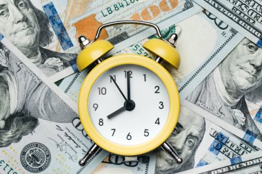 100 Amerikan Doları 'nın üzerindeki sarı alarm saati. Kredi, depozito ve ipotek kavramı.