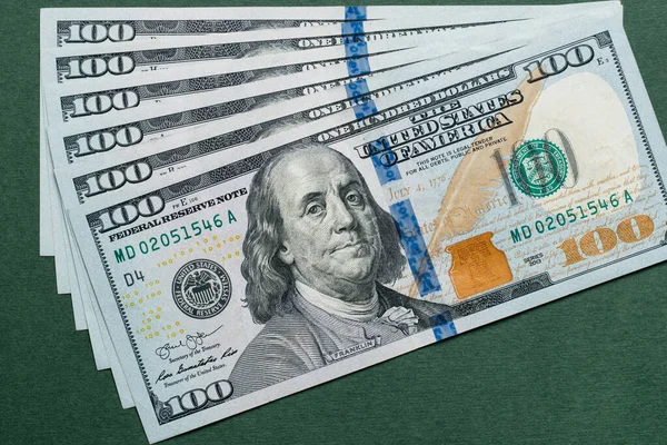 Pilha de cem notas de dólares americanos sobre fundo verde . — Fotografia de Stock