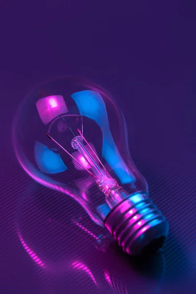 Photo of light bulb lamp in neon light. Ideea concept.