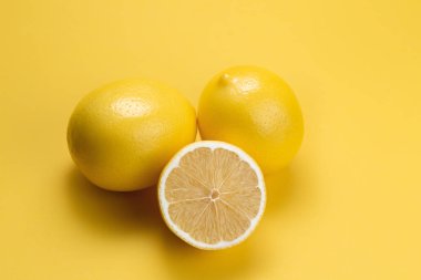 Limon dilimi ve sarı arka planda limon..